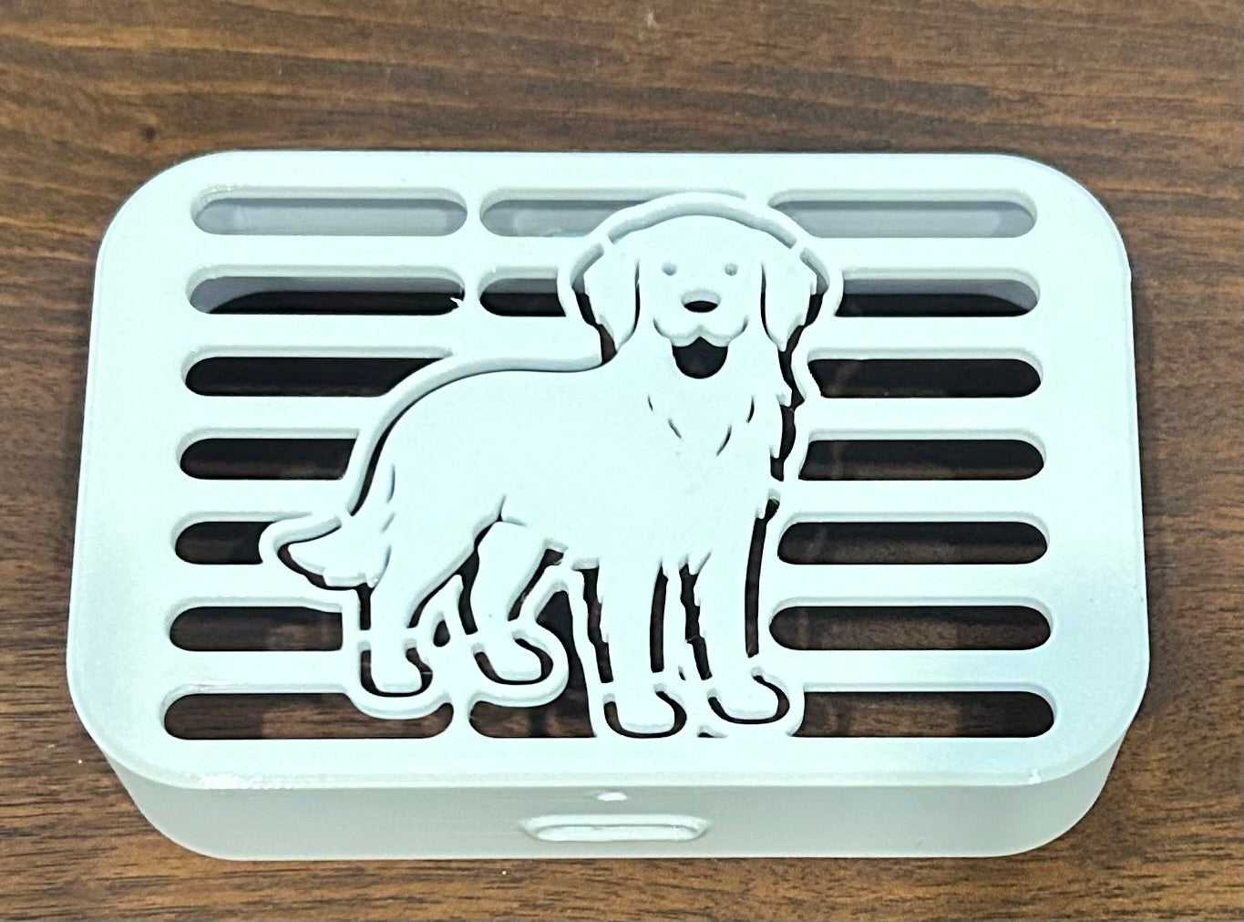 Close-up of golden retriever-shaped decorative downspout cover showing cover detail, Coastal Spouts design.