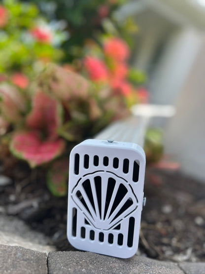Seashell decorative gutter cap installed on beach home downspout, ocean-themed exterior accent by Coastal Spouts.